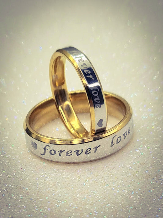 Anillos "Forever Love" tipo alianza de matrimonio o pareja en acero inoxidable bicolor y ancho de 4mm y 6mm. Se incluye grabado de nombres y fecha importante gratis. Posan sobre fondo blanco brillante.