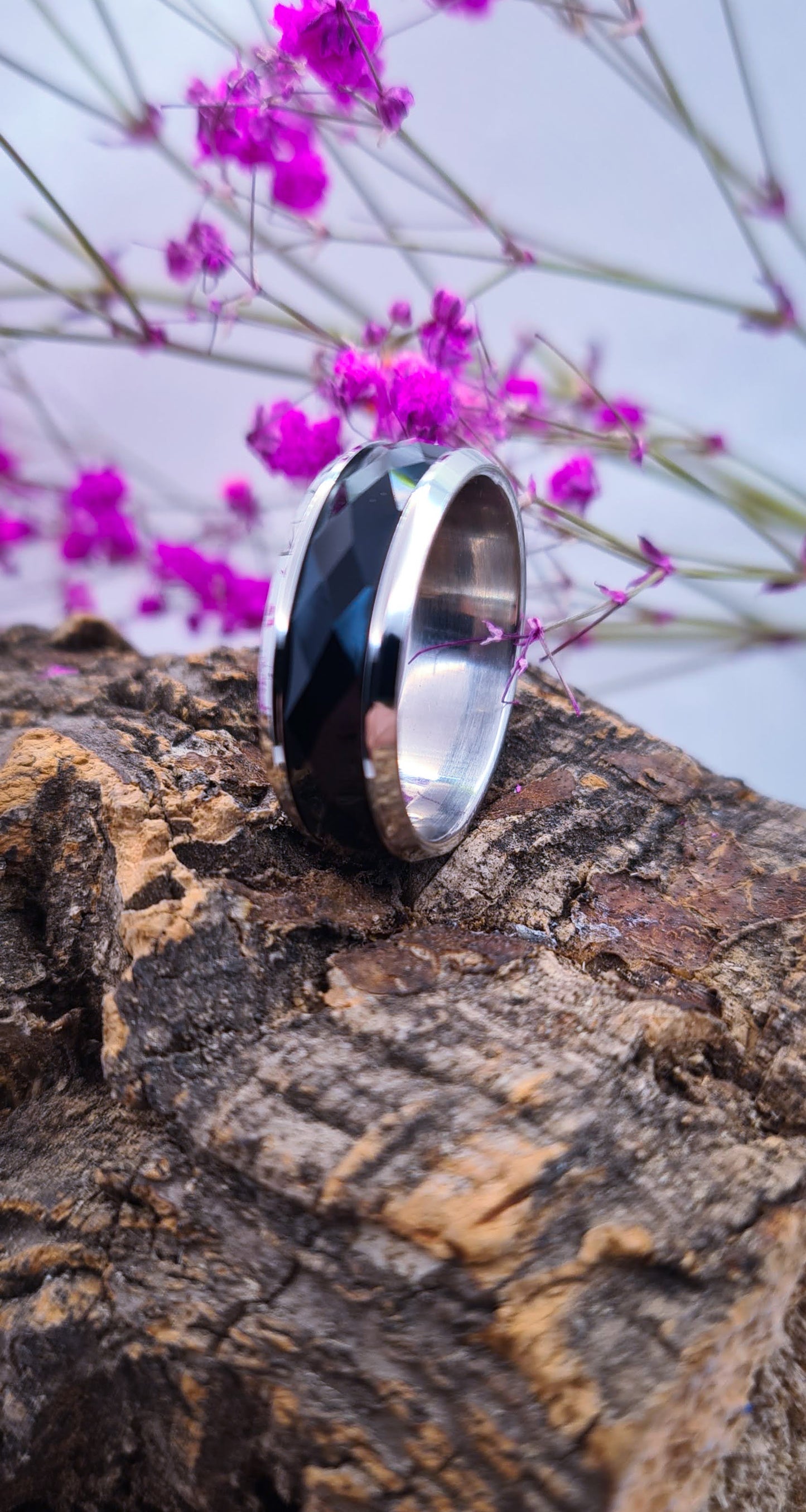 Anillo tipo alianza de matrimonio o pareja en acero inoxidable bicolor negro y ancho de 8mm. Se incluye grabado de nombres y fecha importante gratis. Posa sobre tronco.