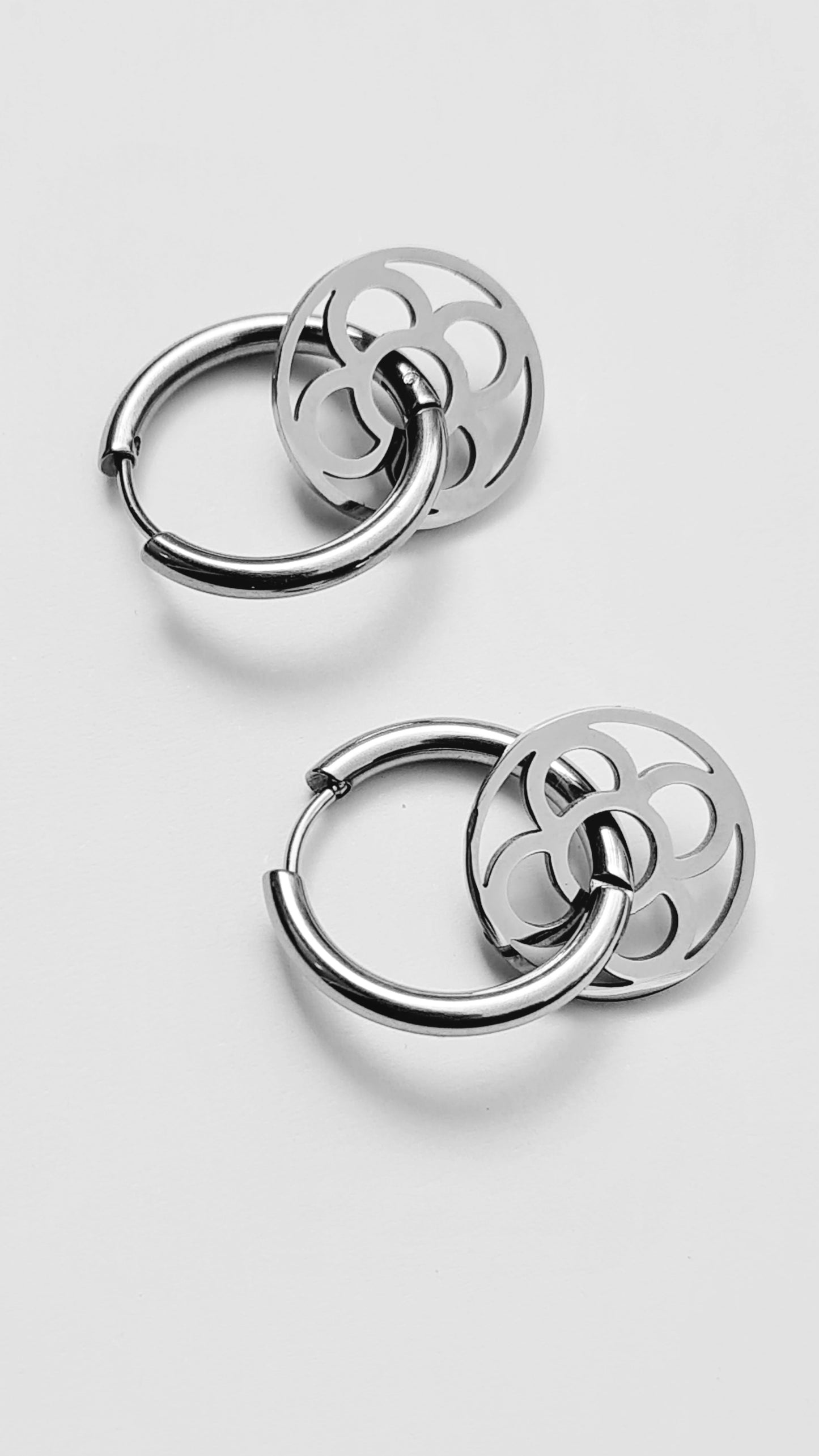 Aros con la Flor de Barcelona de acero inoxidable circular para mujer. Fondo blanco.