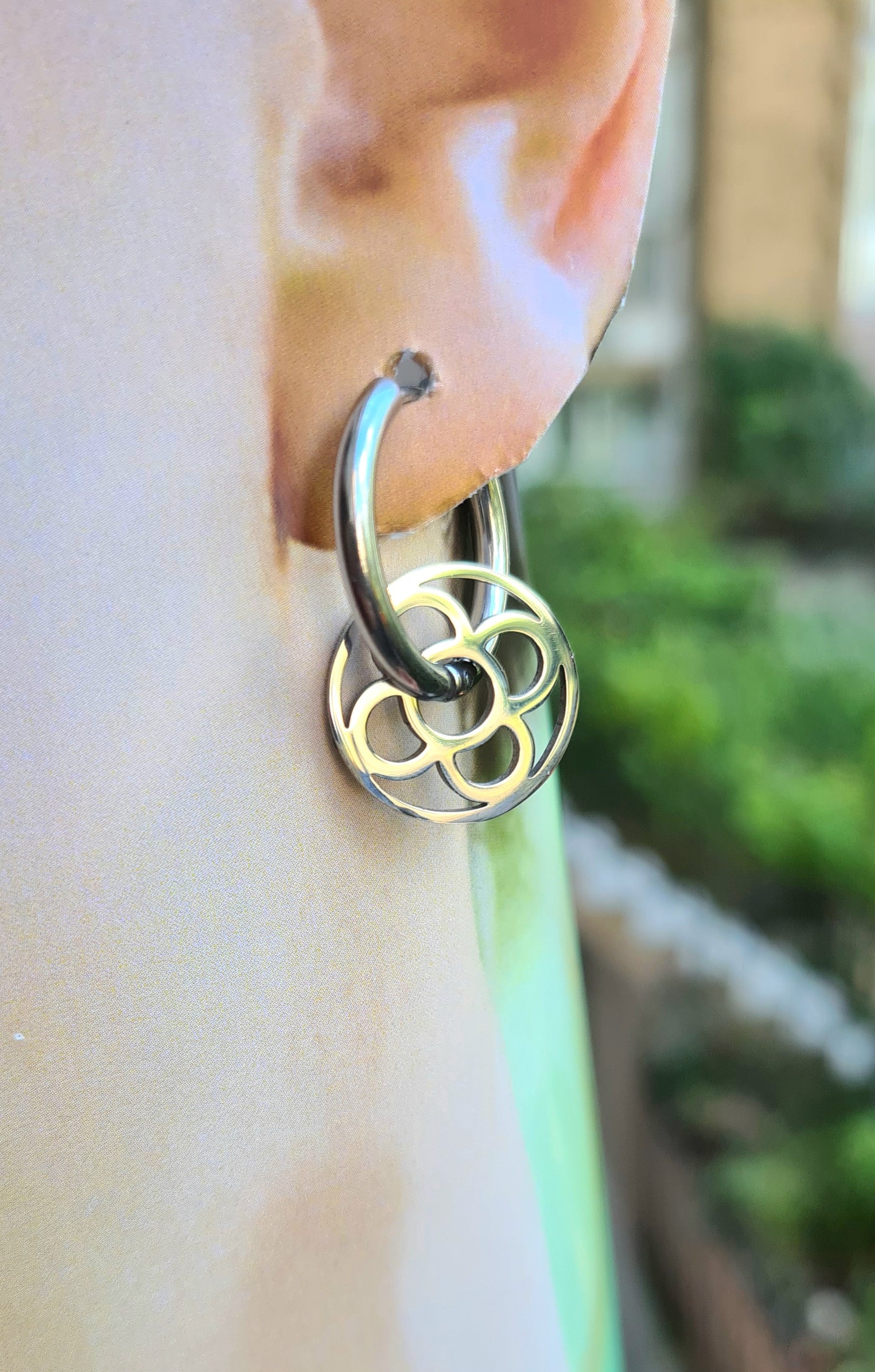 Aros con la Flor de Barcelona de acero inoxidable circular para mujer. Sobre oreja.