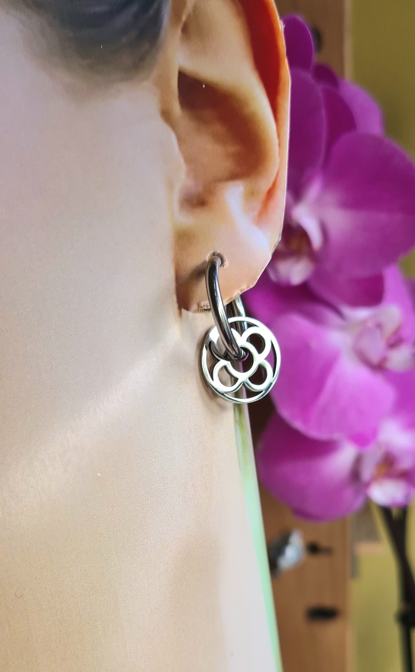 Aros con la Flor de Barcelona de acero inoxidable circular para mujer. Sobre oreja.