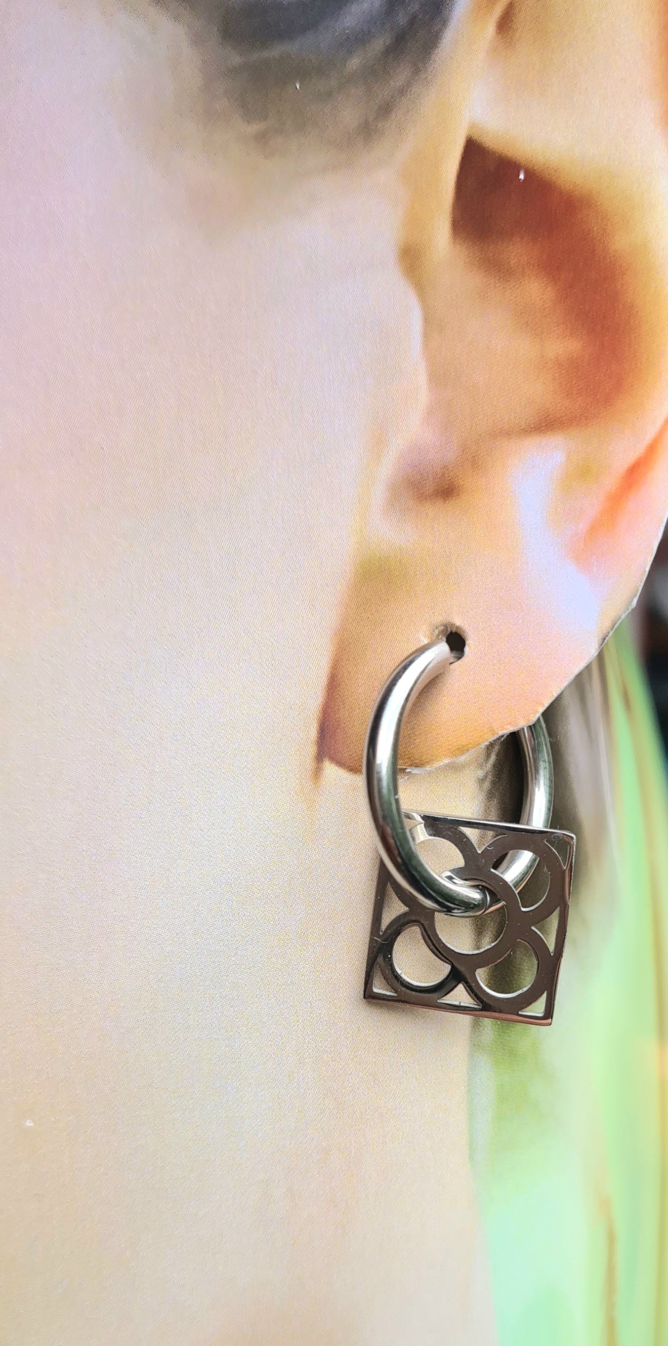 Aros con la Flor de Barcelona de acero inoxidable cuadrada para mujer. Sobre oreja.