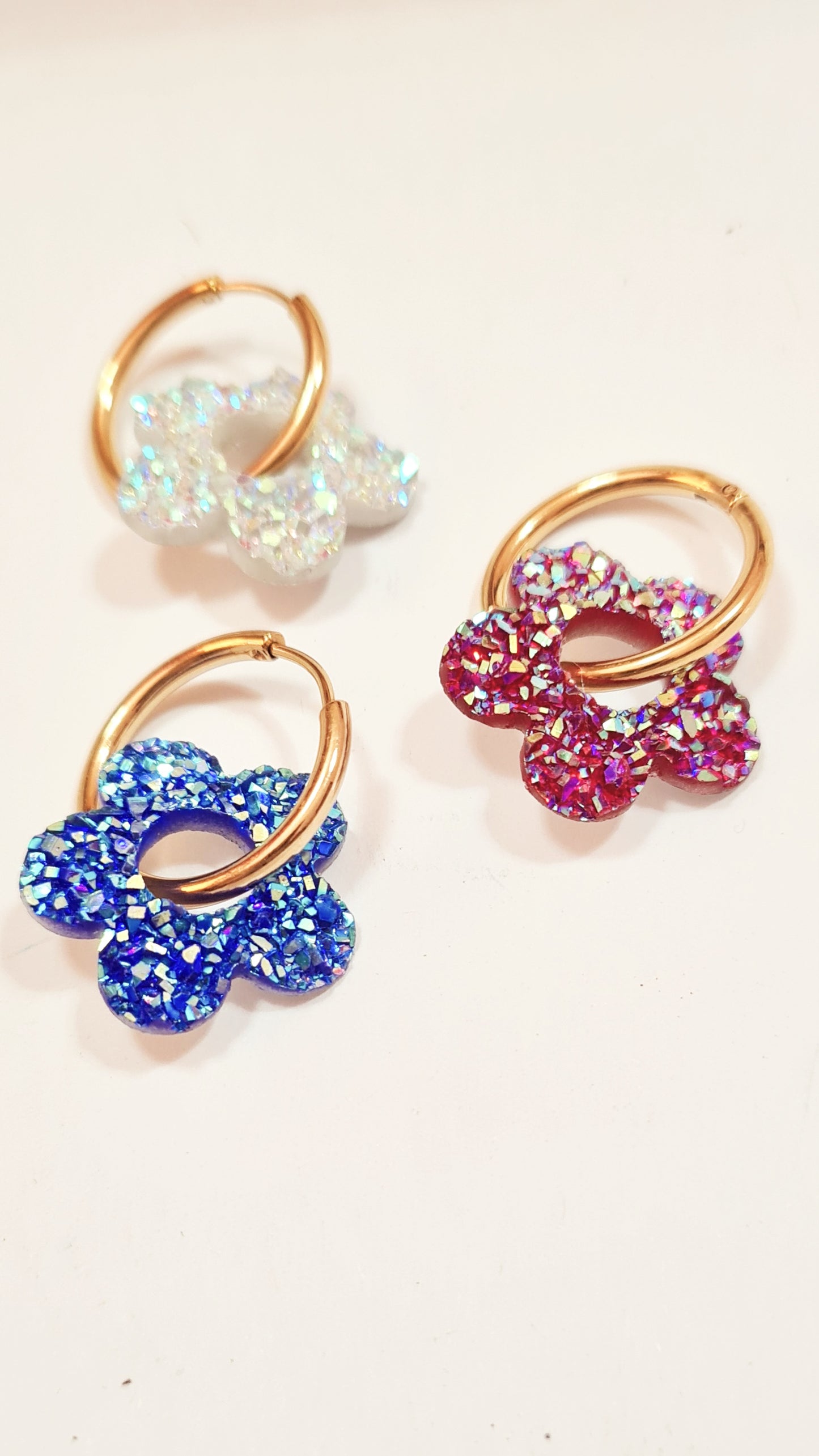 Aros acero inoxidable dorados con Flor de Acrílico Brillante para mujer. Fondo blanco.
