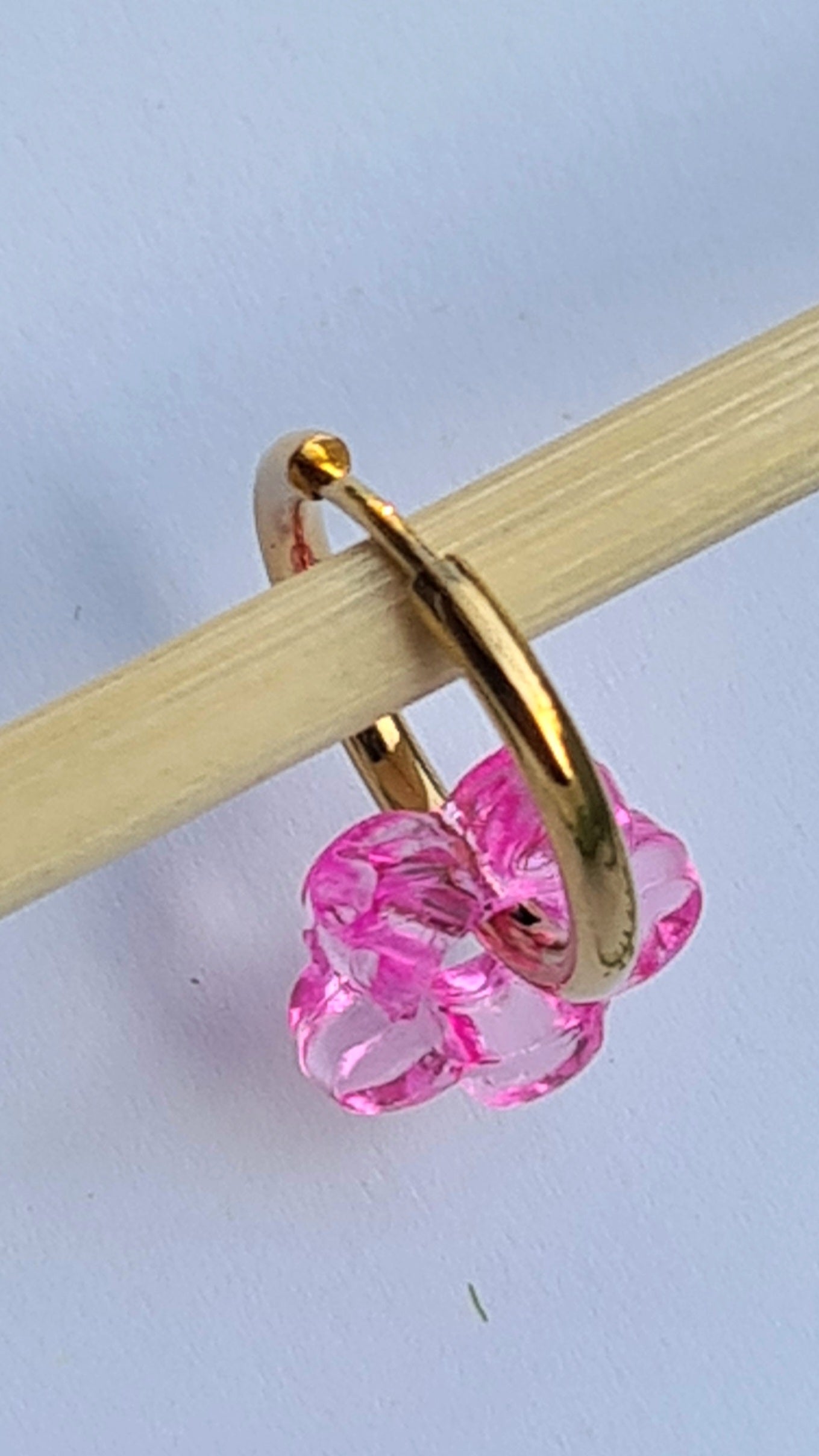 Aros acero inoxidable dorados con Flor de Acrílico para mujer. Fondo blanco.