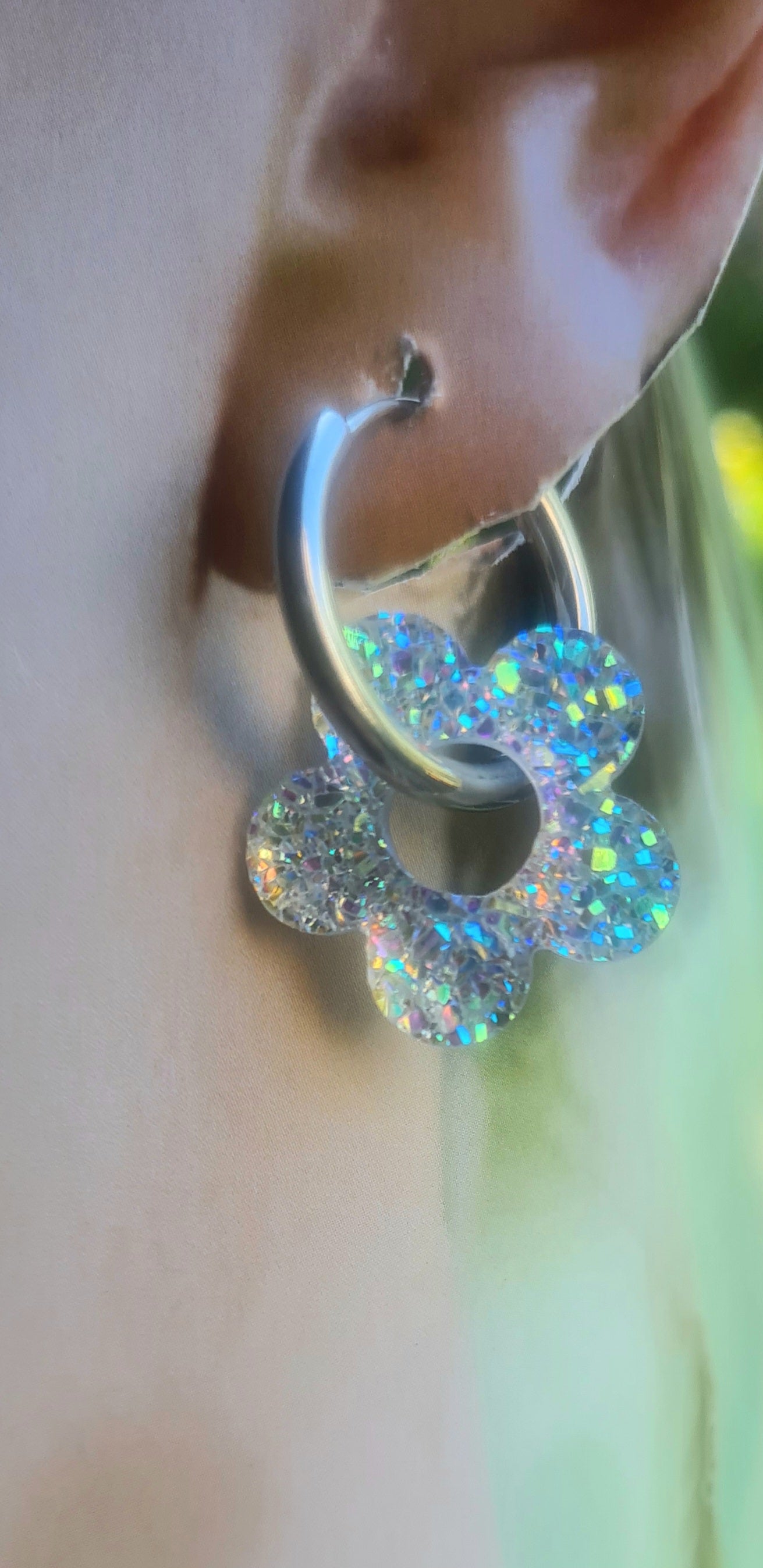 Aros acero inoxidable plateados con Flor de Acrílico Brillante para mujer. Sobre oreja.