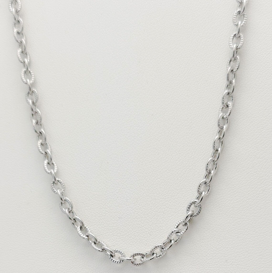 Cadena acero inoxidable modelo Eslabón Forzado Diseño, 4mm de ancho. Posa sobre fondo blanco.