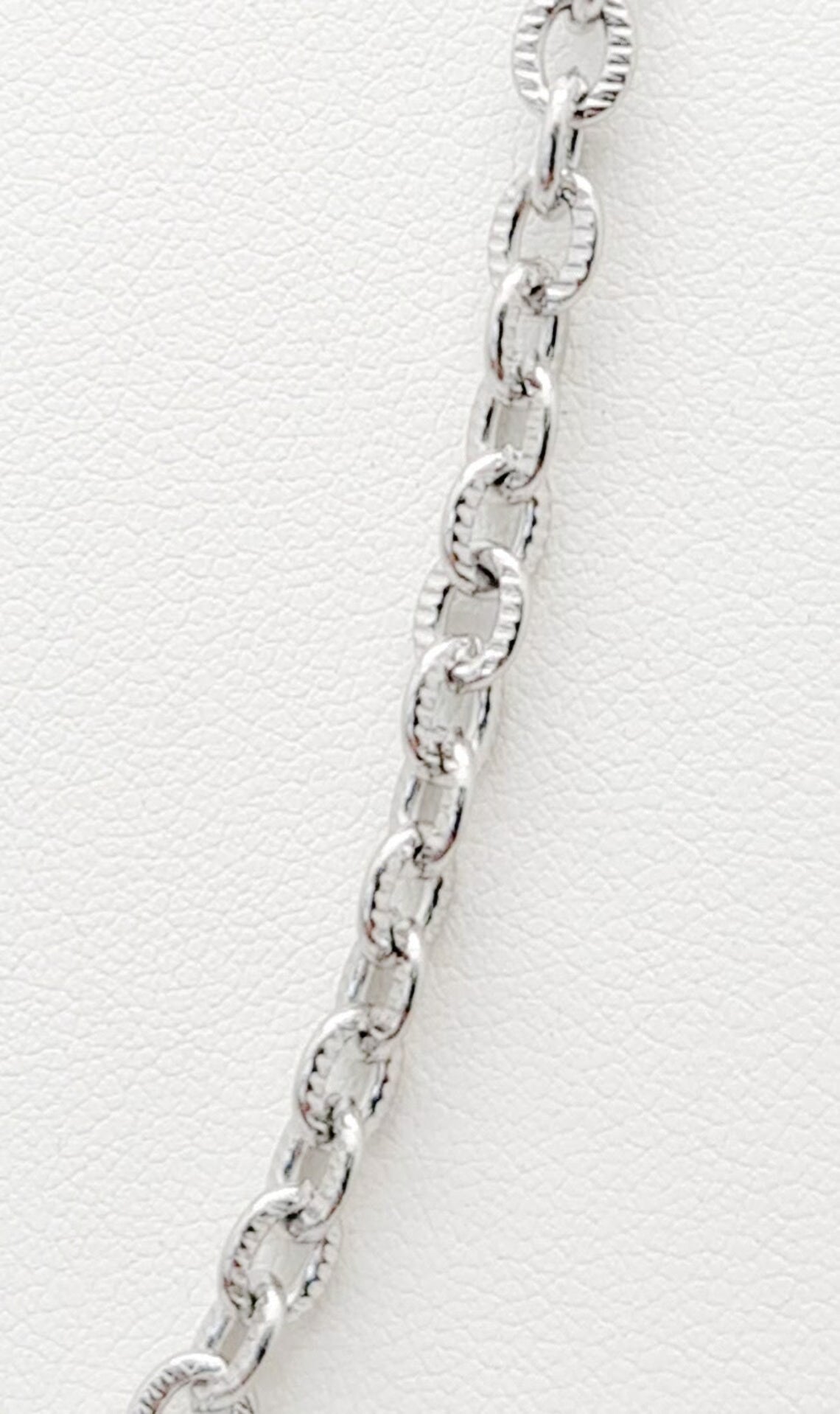 Cadena acero inoxidable modelo Eslabón Forzado Diseño, 4mm de ancho. Posa sobre fondo blanco.