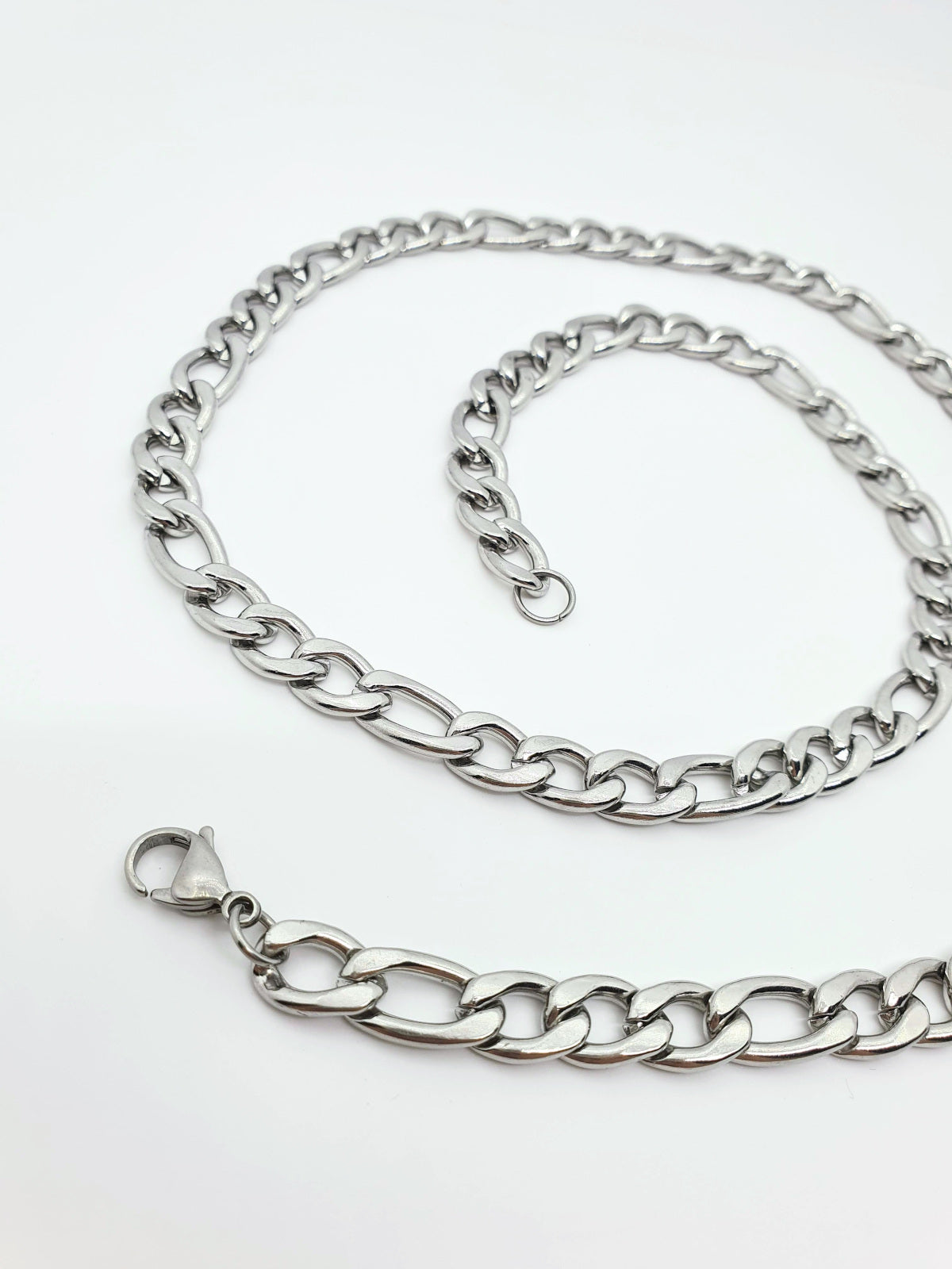 Cadena acero inoxidable modelo Fígaro, 4 anchos. Posa sobre fondo blanco.