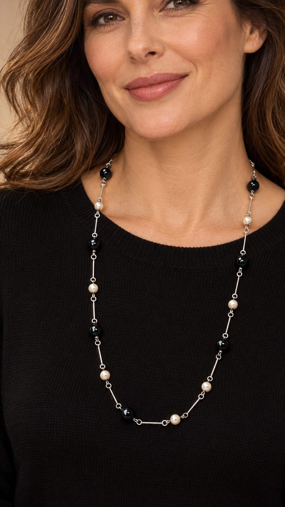 Mujer con collar largo de ónix negro y perlas.