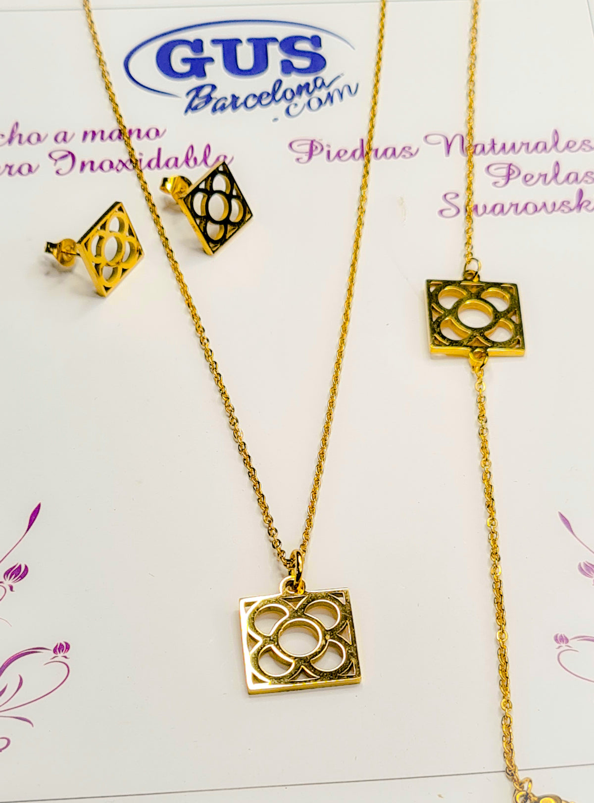 Conjunto Flor de Barcelona Acero Inoxidable dorado para mujer. Posa sobre cartón blanco.