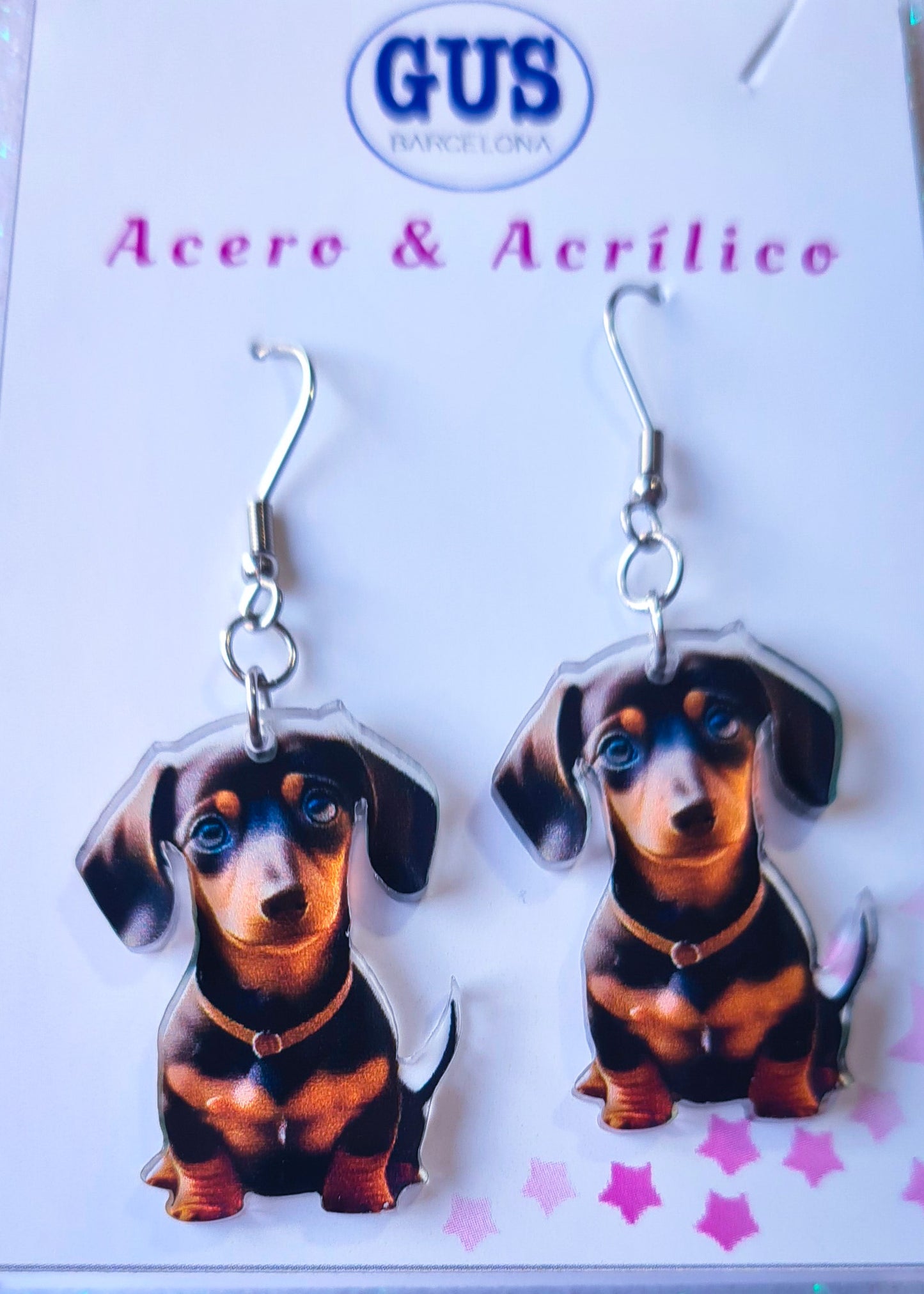 Pendientes perro salchicha para mujer en Acero y Acrílico. Posa sobre cartón blanco.
