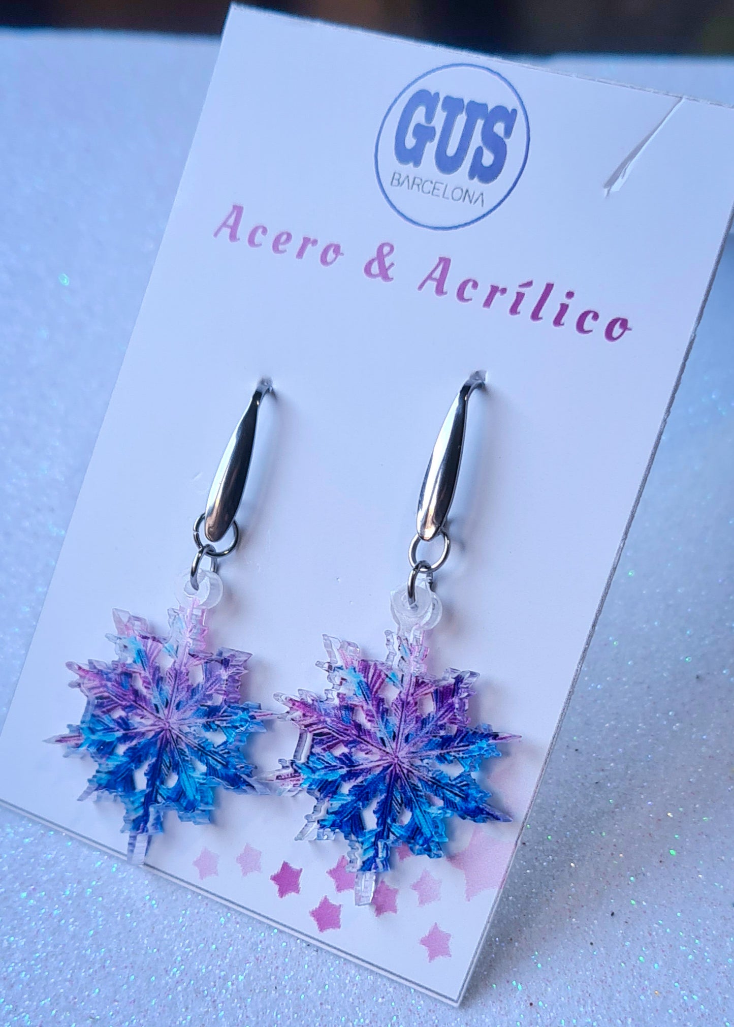 Pendientes Copo de Nieve para mujer en Acero y Acrílico. Posa sobre cartón blanco.