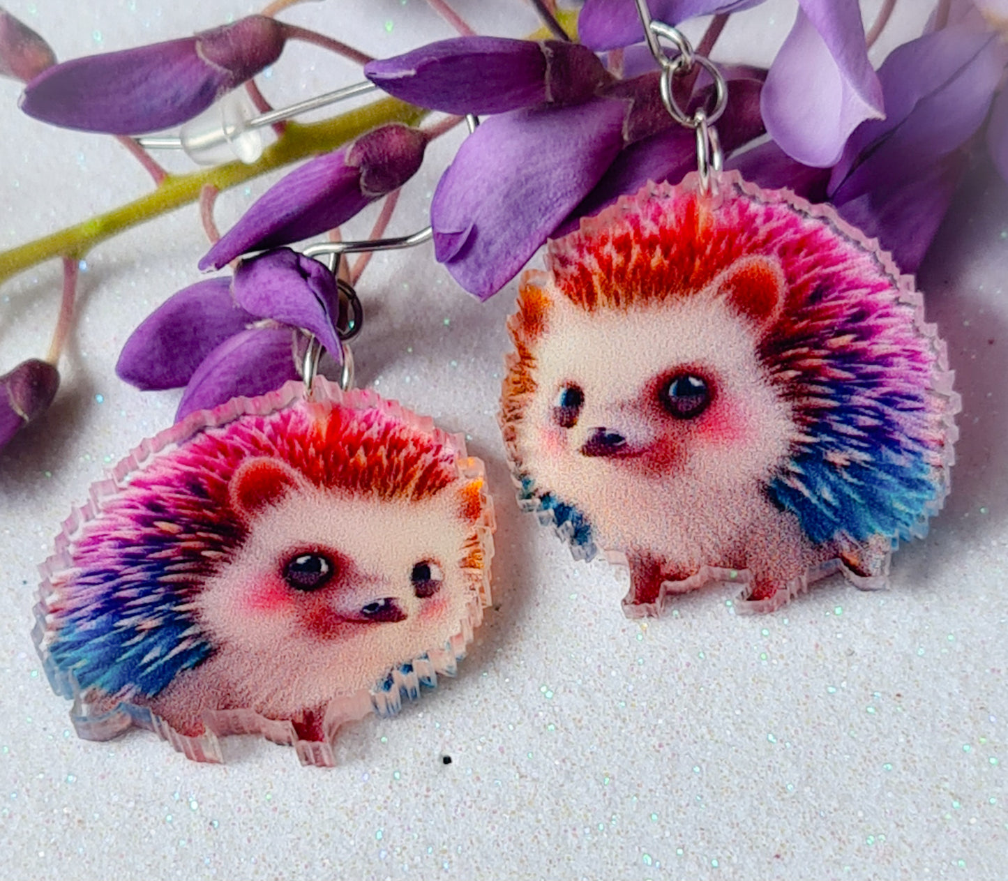 Pendientes Erizo para mujer en Acero y Acrílico. Posa sobre fondo blanco y flores.