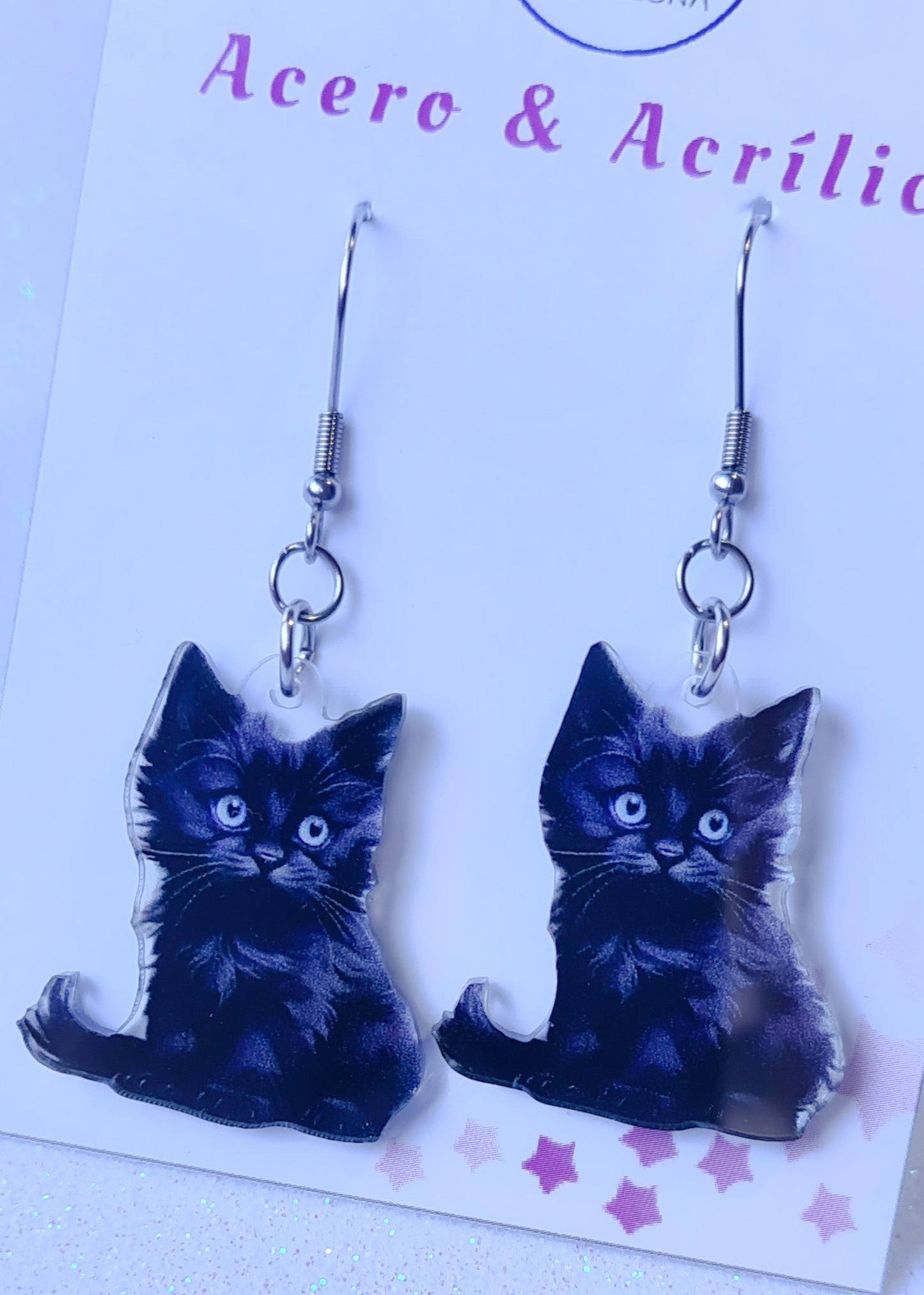 Pendientes Gato Negro para mujer en Acero y Acrílico. Posa sobre cartón blanco.