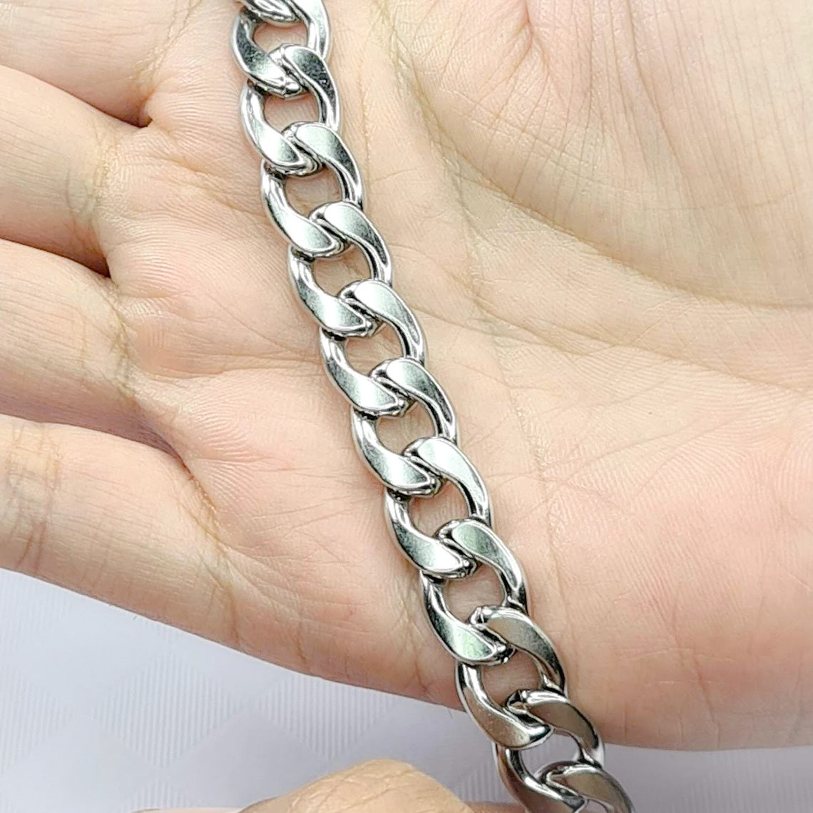 Pulsera acero inoxidable modelo Eslabón Grande, 12mm de ancho. Posa sobre mano de modelo.