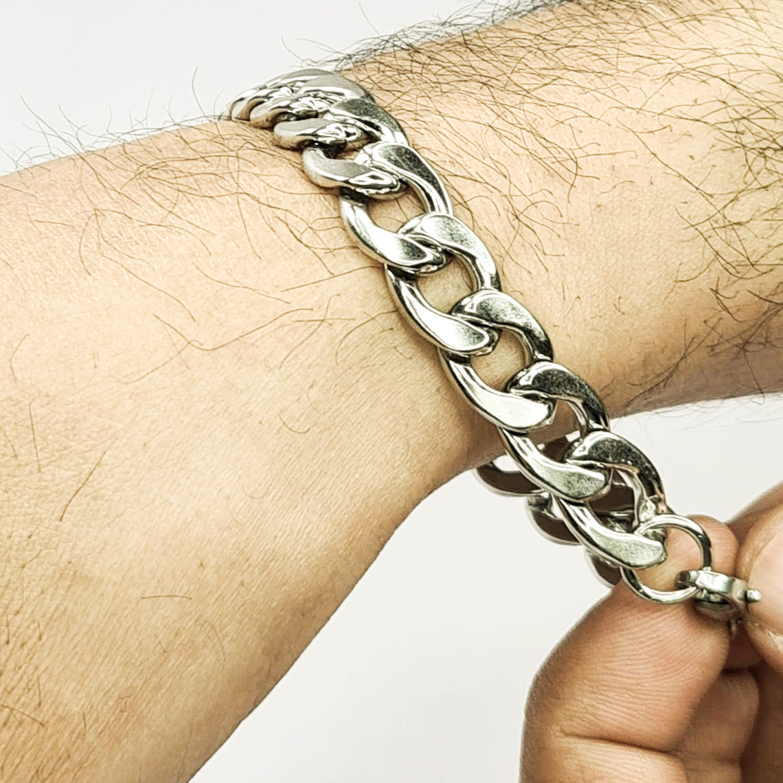 Pulsera acero inoxidable modelo Eslabón Grande, 12mm de ancho. Posa sobre mano de modelo.