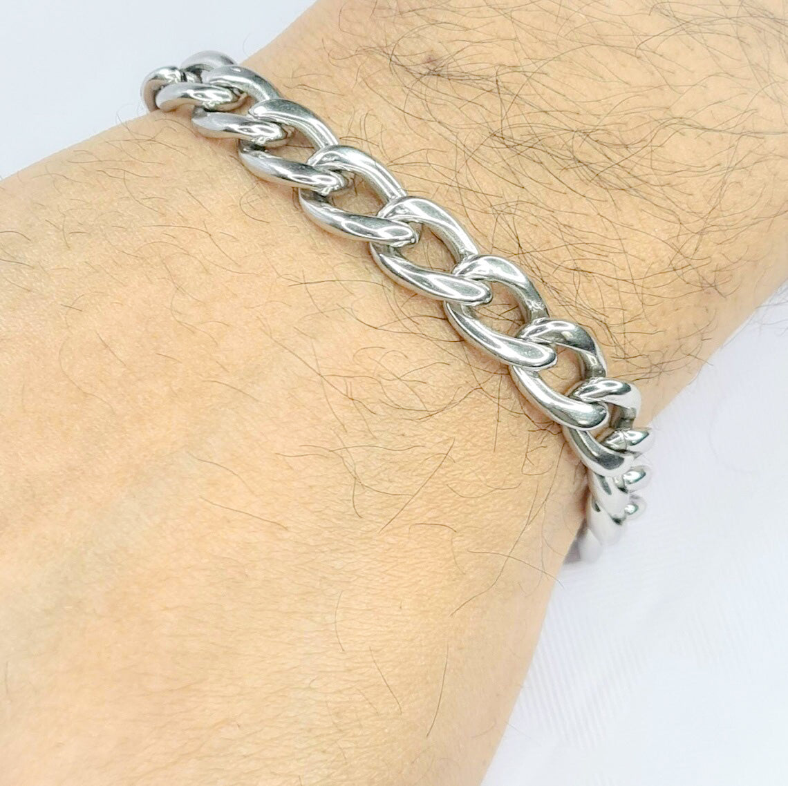 Pulsera acero inoxidable modelo Eslabón Largo, 10mm de ancho. Posa sobre mano de modelo.