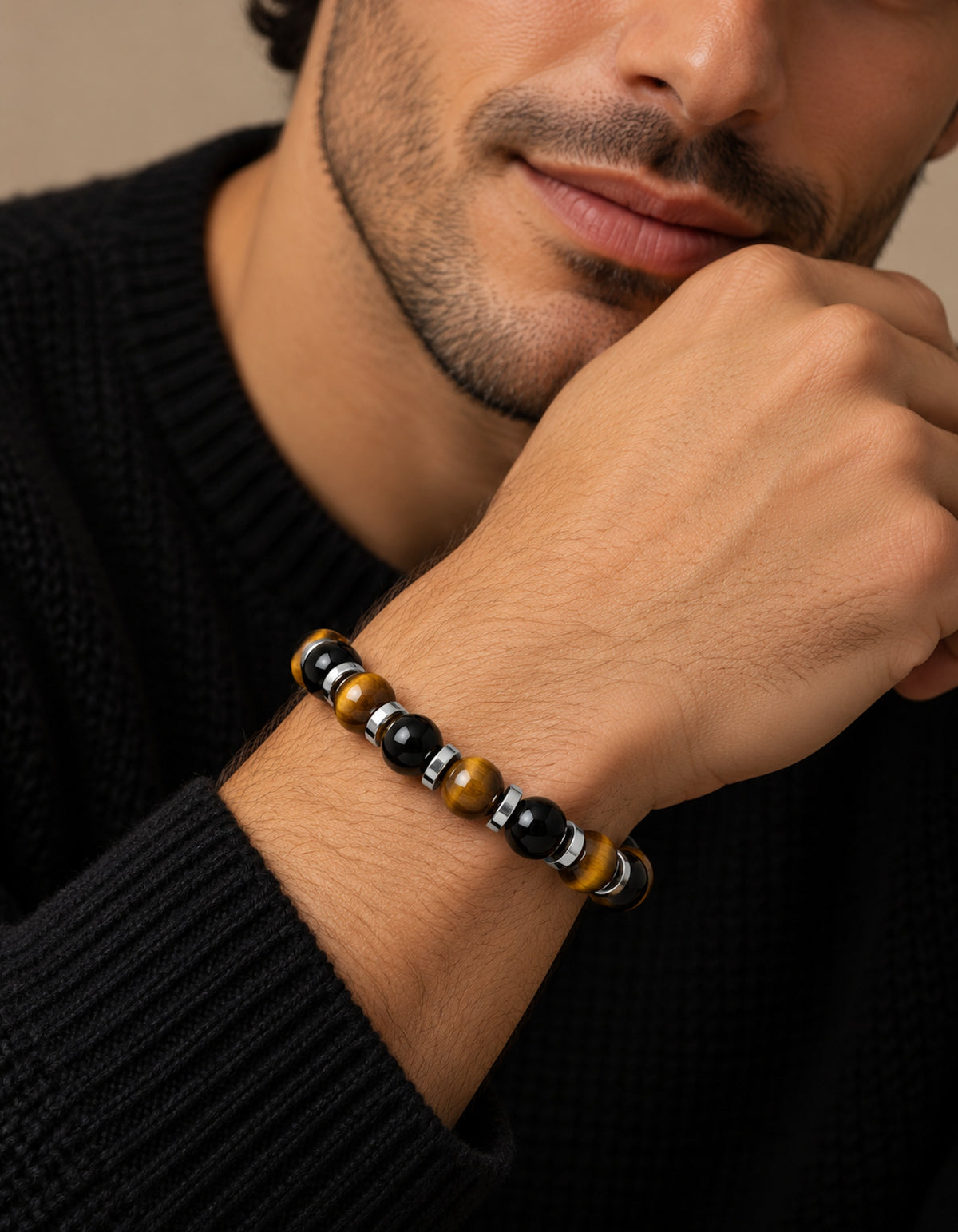 Hombre llevando pulsera de ónix brillante y ojo de tigre con separadores metálicos.