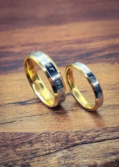 Anillos "Forever Love" tipo alianza de matrimonio o pareja en acero inoxidable bicolor y ancho de 4mm y 6mm. Se incluye grabado de nombres y fecha importante gratis. Posan sobre madera.