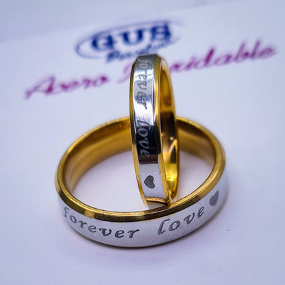 Anillos "Forever Love" tipo alianza de matrimonio o pareja en acero inoxidable bicolor y ancho de 4mm y 6mm. Se incluye grabado de nombres y fecha importante gratis. Posan sobre cartón Gus Barcelona.