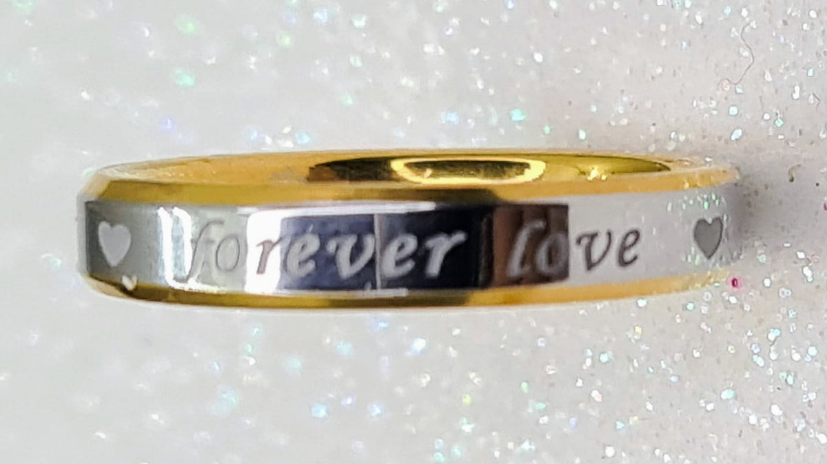 Vista frontal de alianza bicolor fina con corazones y frase "Forever Love".