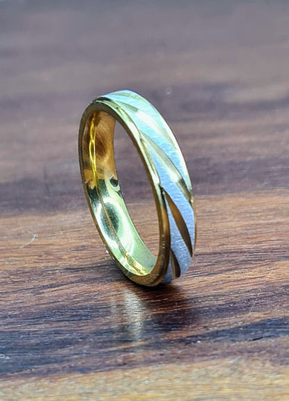 Anillo de acero inoxidable bicolor sobre superficie de madera.