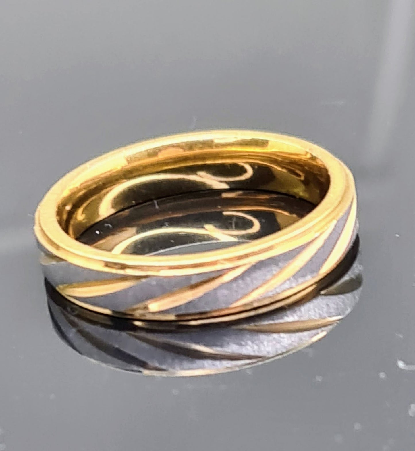Anillo bicolor dorado y plateado de 4 mm sobre fondo neutro.
