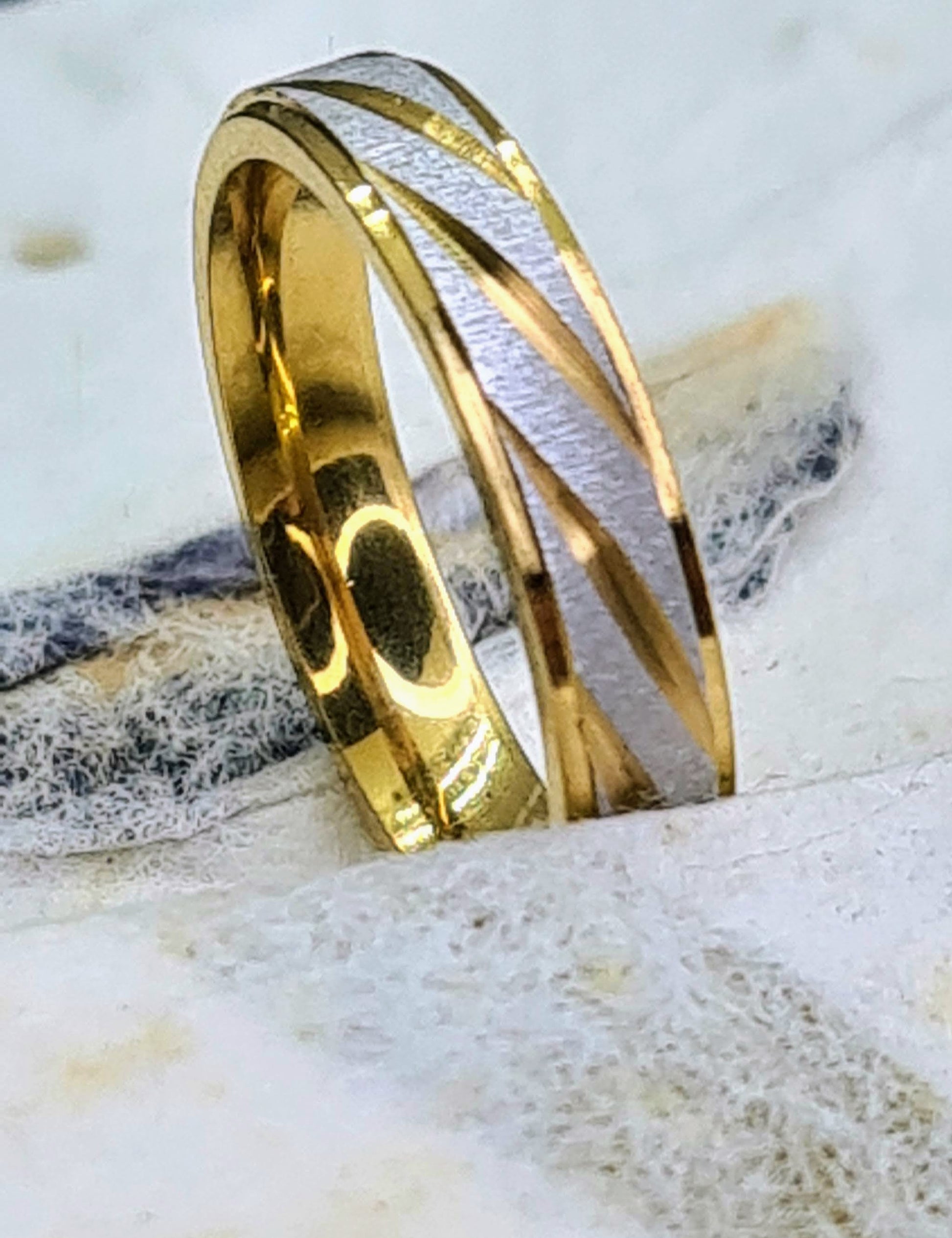 Primer plano de anillo bicolor de acero inoxidable con detalle del acabado.