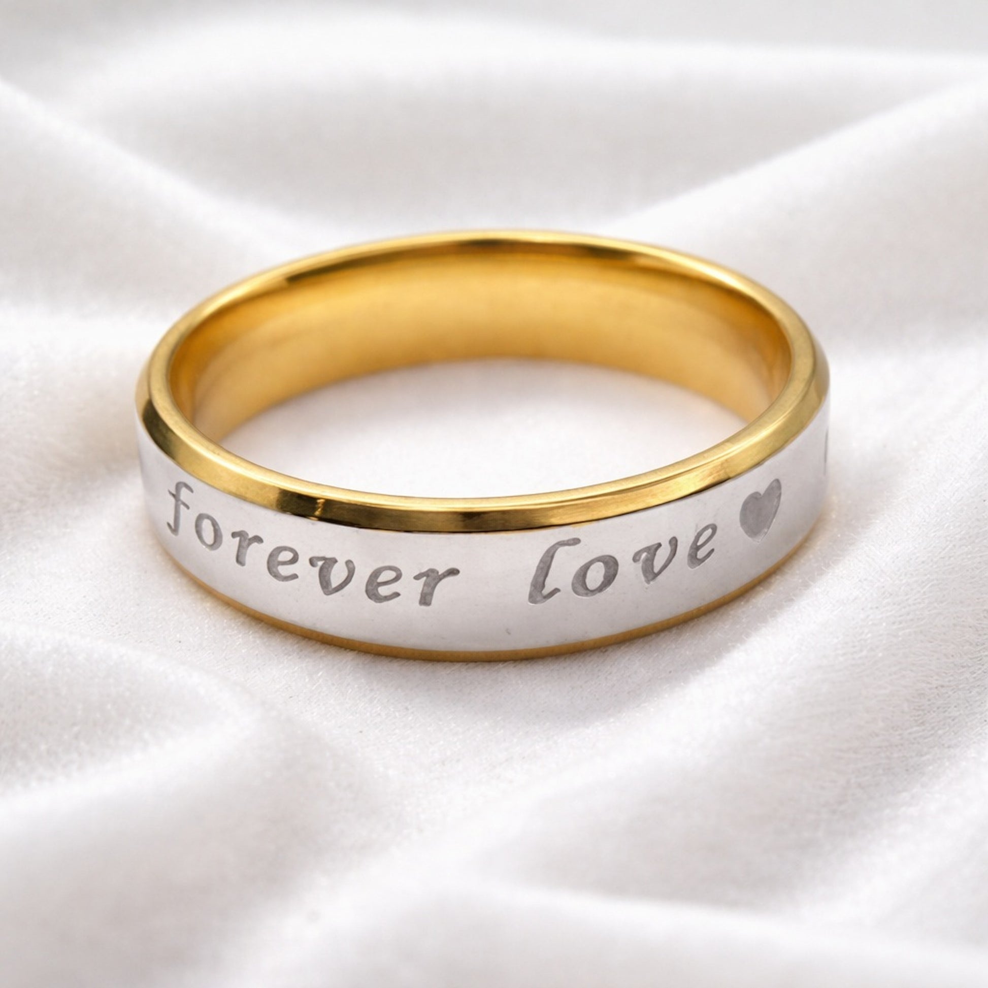 Anillo de pareja bicolor dorado y plateado de 6 mm sobre tela blanca.