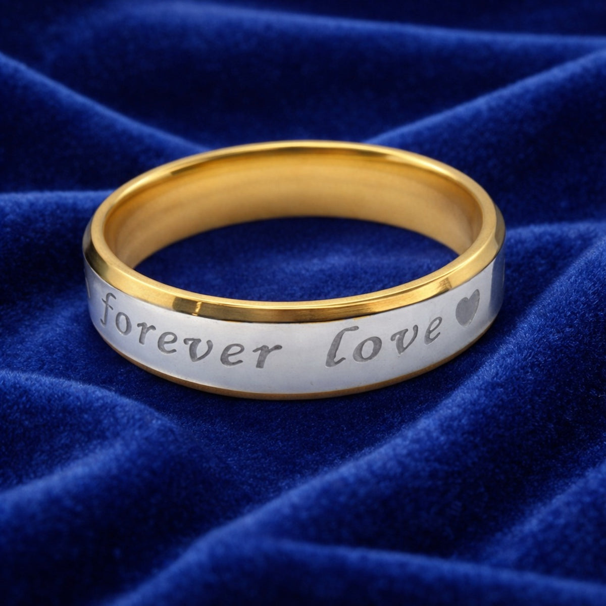 Alianza bicolor de acero inoxidable de 6 mm con frase "Forever Love" sobre terciopelo azul.