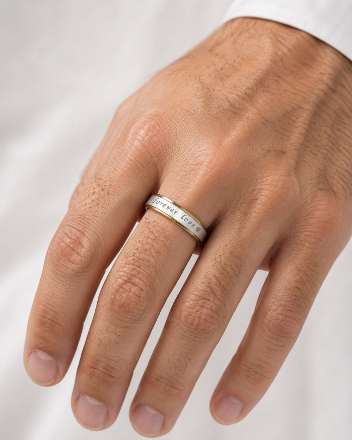 Alianza bicolor de acero inoxidable de 6 mm puesta en la mano de un hombre.