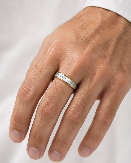 Alianza bicolor de acero inoxidable de 6 mm puesta en la mano de un hombre.