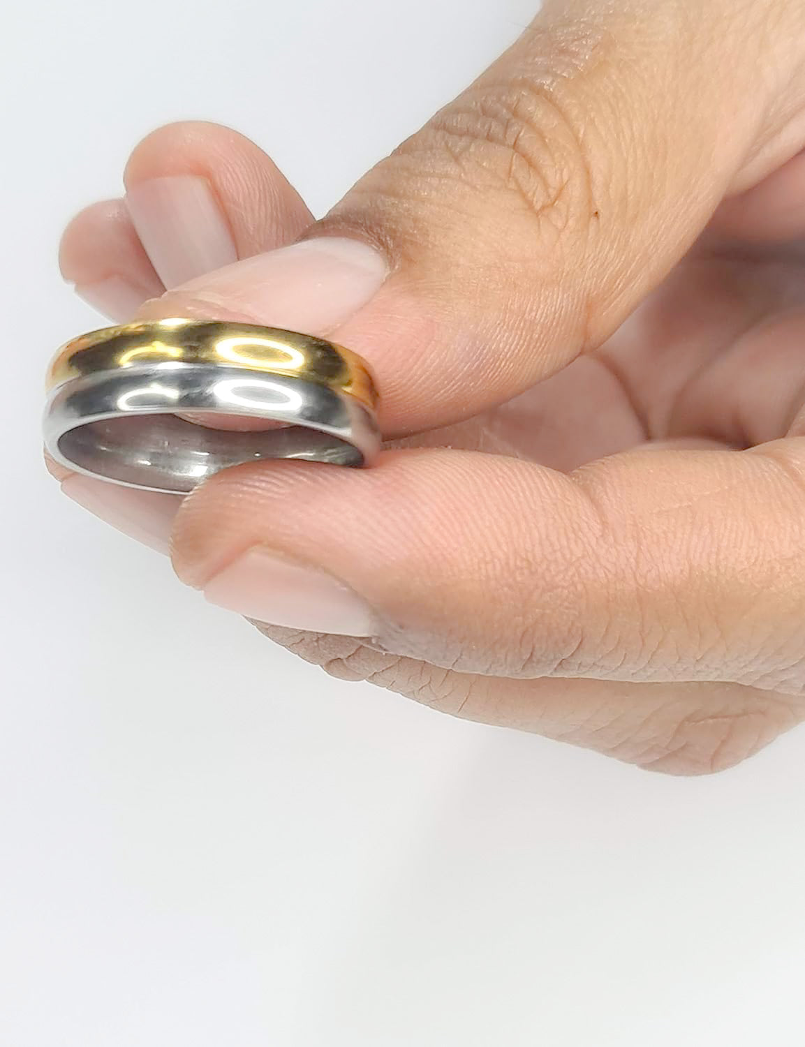 Anillo tipo alianza de matrimonio o pareja en acero inoxidable bicolor y ancho de 6mm. Se incluye grabado de nombres y fecha importante gratis. Posa sobre mano de hombre.