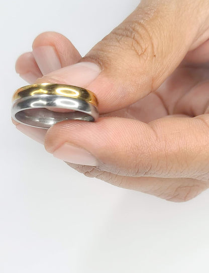 Anillo tipo alianza de matrimonio o pareja en acero inoxidable bicolor y ancho de 6mm. Se incluye grabado de nombres y fecha importante gratis. Posa sobre mano de hombre.