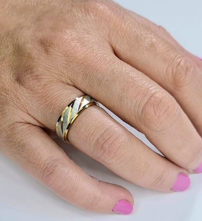 Alianza de acero inoxidable de 6 mm puesta en mano de mujer.