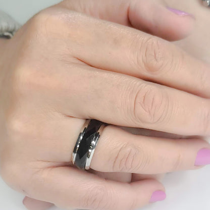 Anillo tipo alianza de matrimonio o pareja en acero inoxidable bicolor negro y ancho de 8mm. Se incluye grabado de nombres y fecha importante gratis. Posa sobre mano de mujer.
