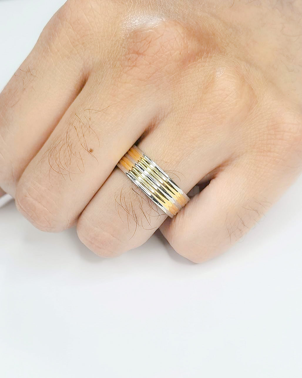 Anillo tipo alianza de matrimonio o pareja en acero inoxidable bicolor y ancho de 8mm. Se incluye grabado de nombres y fecha importante gratis. Posa sobre mano de hombre.