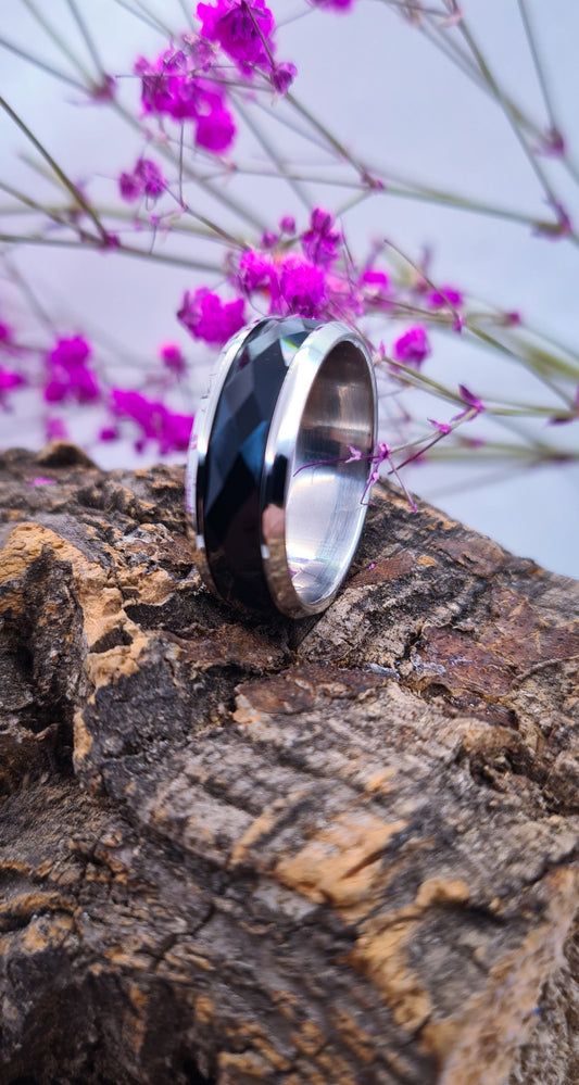 Anillo tipo alianza de matrimonio o pareja en acero inoxidable bicolor negro y ancho de 8mm. Se incluye grabado de nombres y fecha importante gratis. Posa sobre tronco.