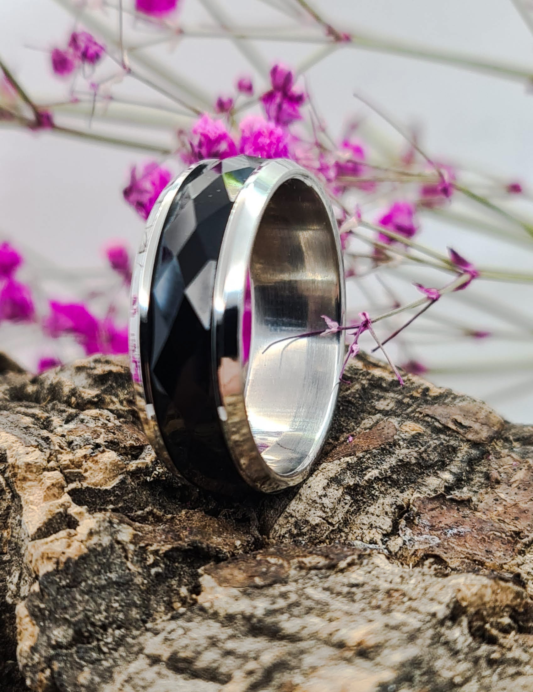 Anillo tipo alianza de matrimonio o pareja en acero inoxidable bicolor negro y ancho de 8mm. Se incluye grabado de nombres y fecha importante gratis. Posa sobre tronco.
