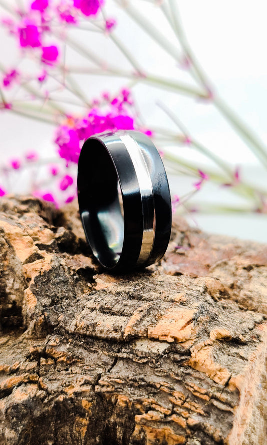 Anillo tipo alianza de matrimonio o pareja en acero inoxidable bicolor negro y ancho de 8mm. Se incluye grabado de nombres y fecha importante gratis. Posa sobre tronco.