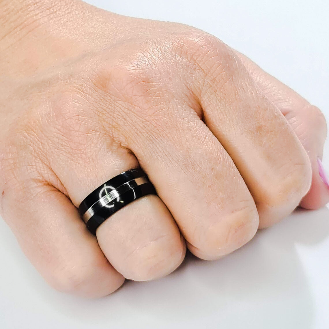 Anillo tipo alianza de matrimonio o pareja en acero inoxidable bicolor negro y ancho de 8mm. Se incluye grabado de nombres y fecha importante gratis. Posa sobre mano de mujer.