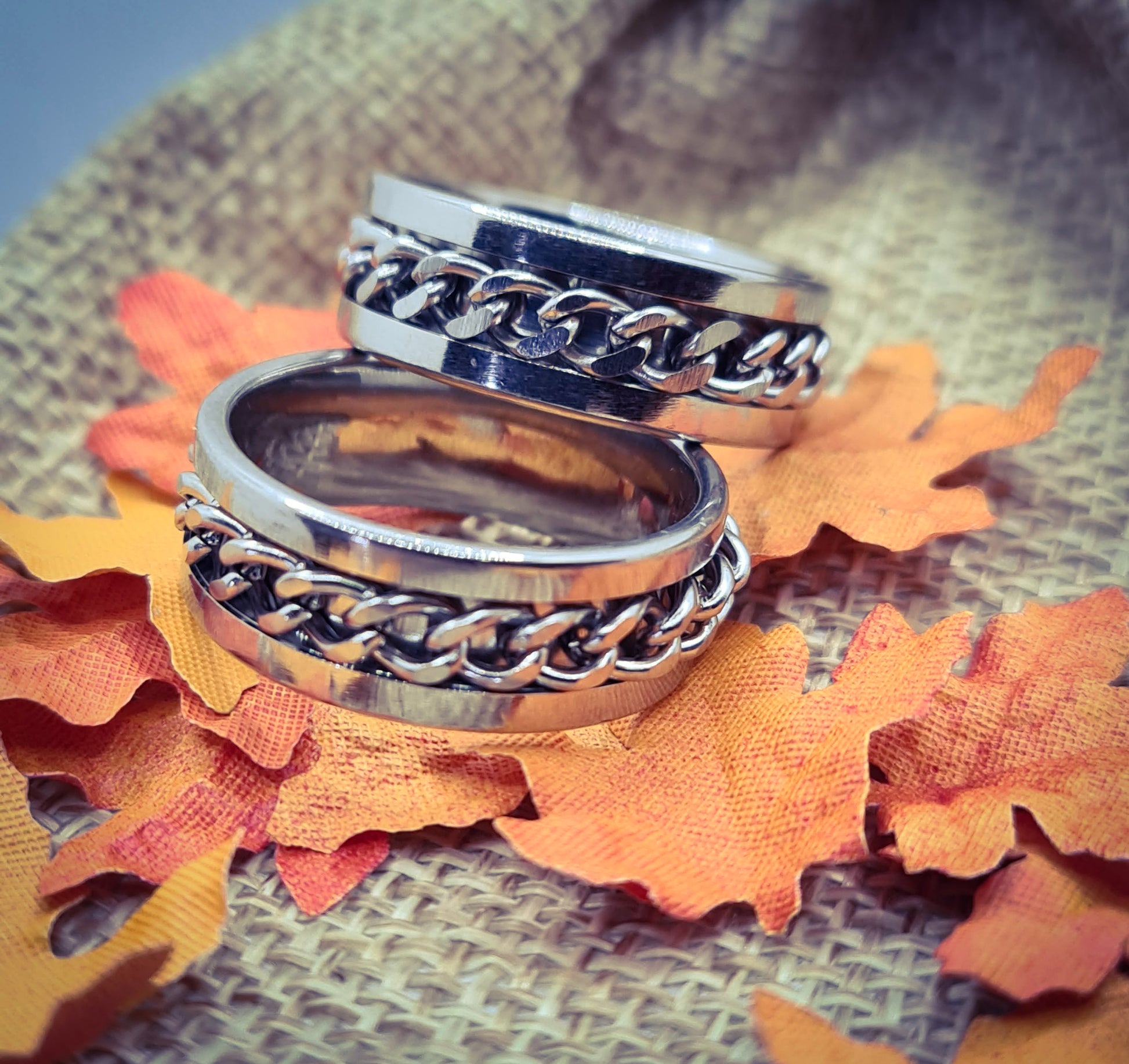Dos Anillos tipo alianza de matrimonio o pareja en acero inoxidable con cadena y ancho de 8mm. Se incluye grabado de nombres y fecha importante gratis. Posan sobre saco.