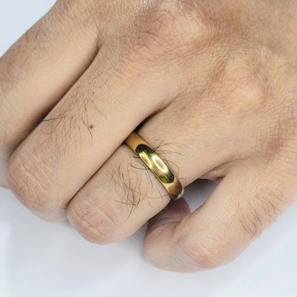 Alianza dorada de acero inoxidable de 4 mm puesta en una mano masculina.