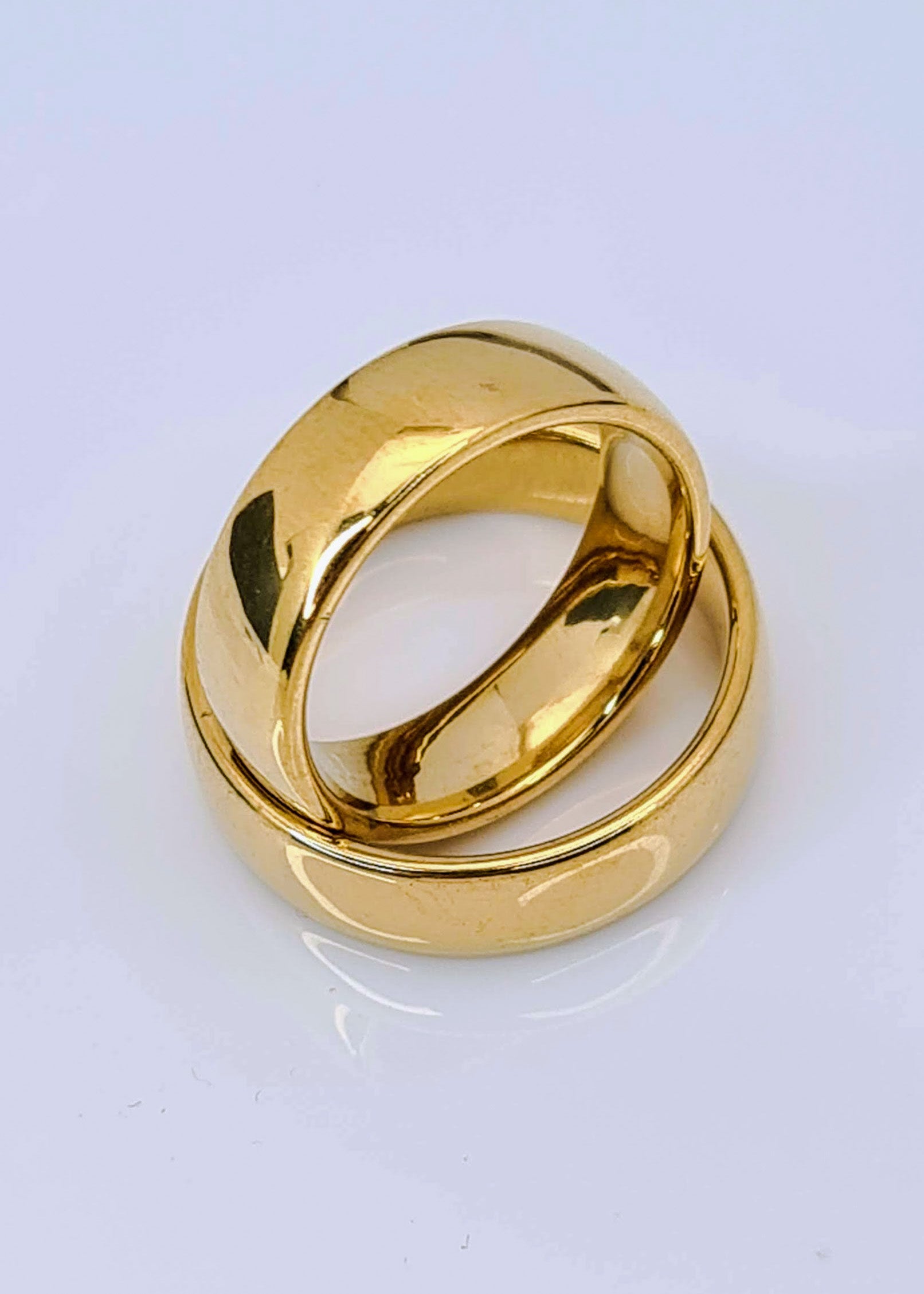Par de Anillos tipo alianza de matrimonio o pareja en acero inoxidable en color dorado y ancho de 6mm sobre fondo blanco. Se incluye grabado de nombres y fecha importante gratis.