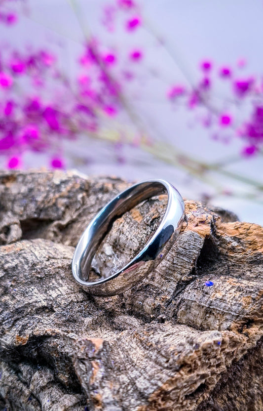 Anillo tipo alianza de matrimonio o pareja en acero inoxidable media caña ancho de 4mm. Se incluye grabado de nombres y fecha importante gratis. Posa sobre tronco.