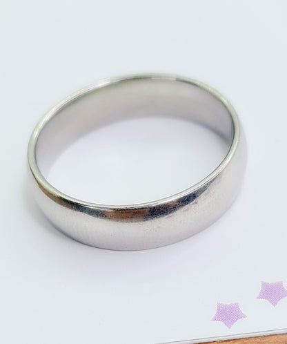 Anillo tipo alianza de matrimonio o pareja en acero inoxidable media caña ancho de 6mm. Se incluye grabado de nombres y fecha importante gratis. Posa sobre cartón.