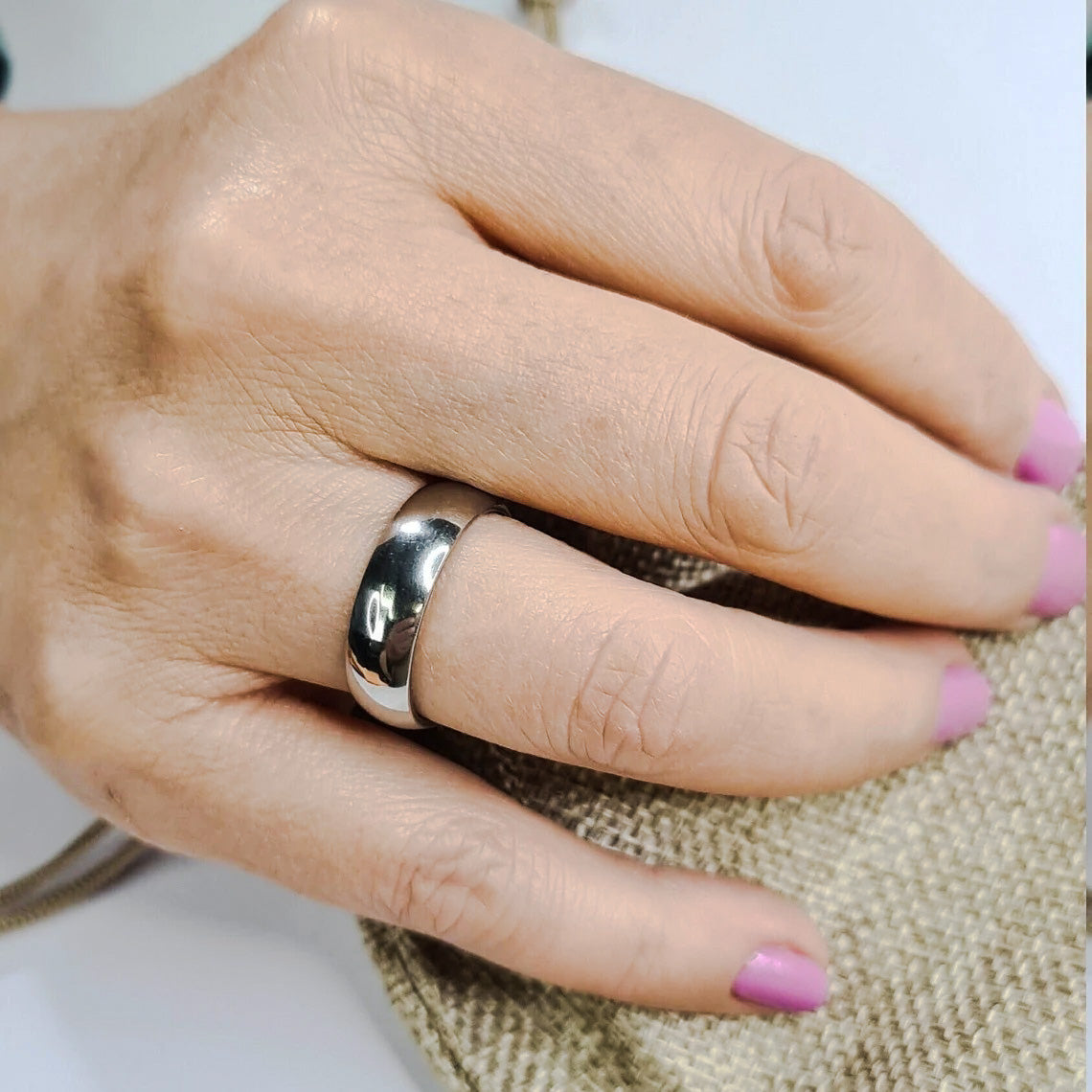 Anillo tipo alianza de matrimonio o pareja en acero inoxidable media caña ancho de 6mm. Se incluye grabado de nombres y fecha importante gratis. Posa sobre mano de mujer.