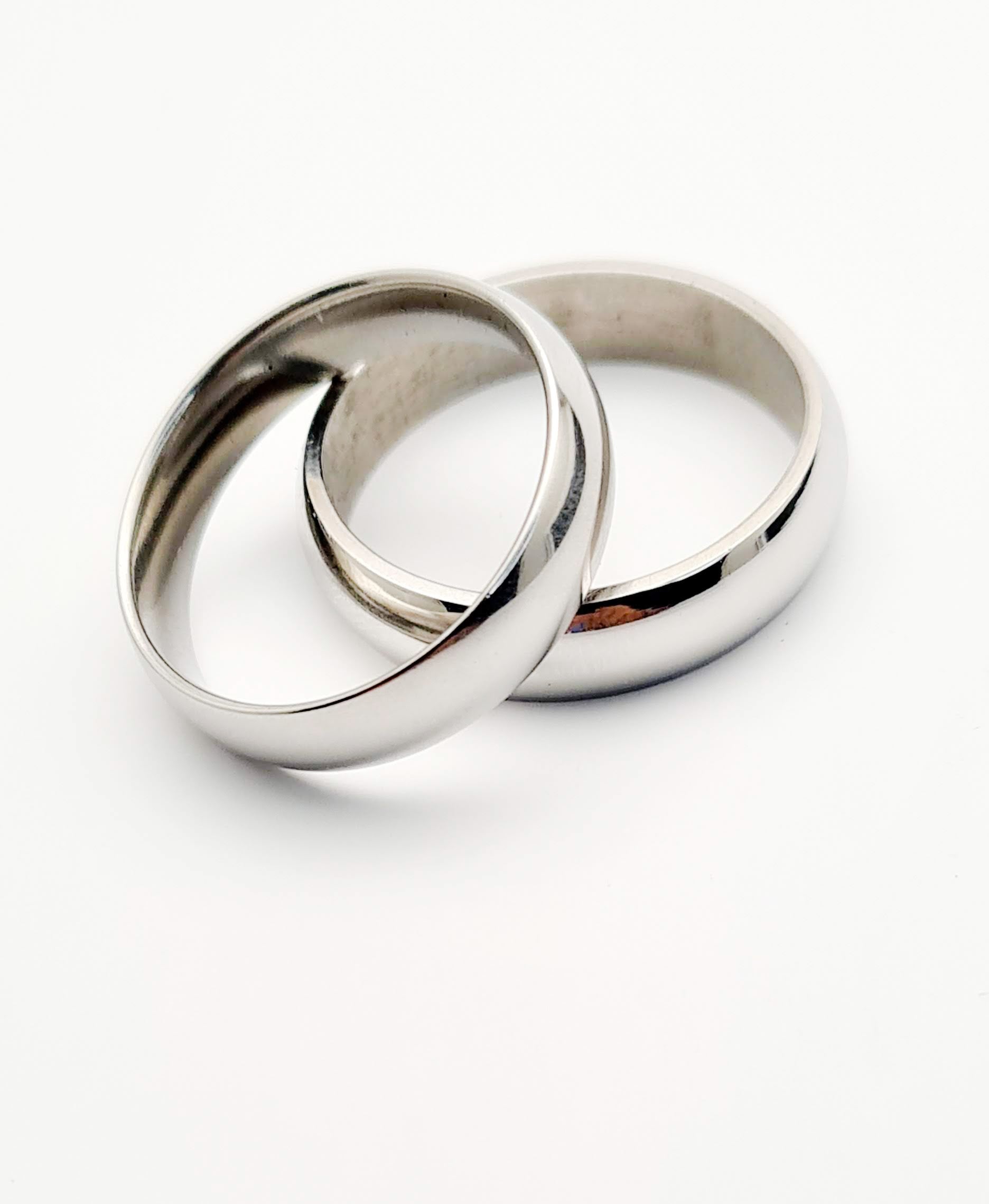 Dos Anillos tipo alianza de matrimonio o pareja en acero inoxidable media caña ancho de 6mm. Se incluye grabado de nombres y fecha importante gratis. Posan sobre cartón.