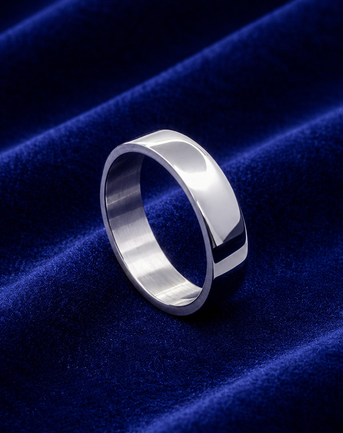 Alianza plana de acero inoxidable de 6 mm sobre terciopelo azul.