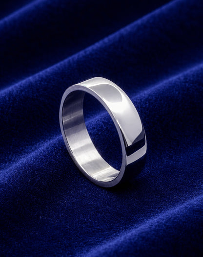 Alianza plana de acero inoxidable de 6 mm sobre terciopelo azul.